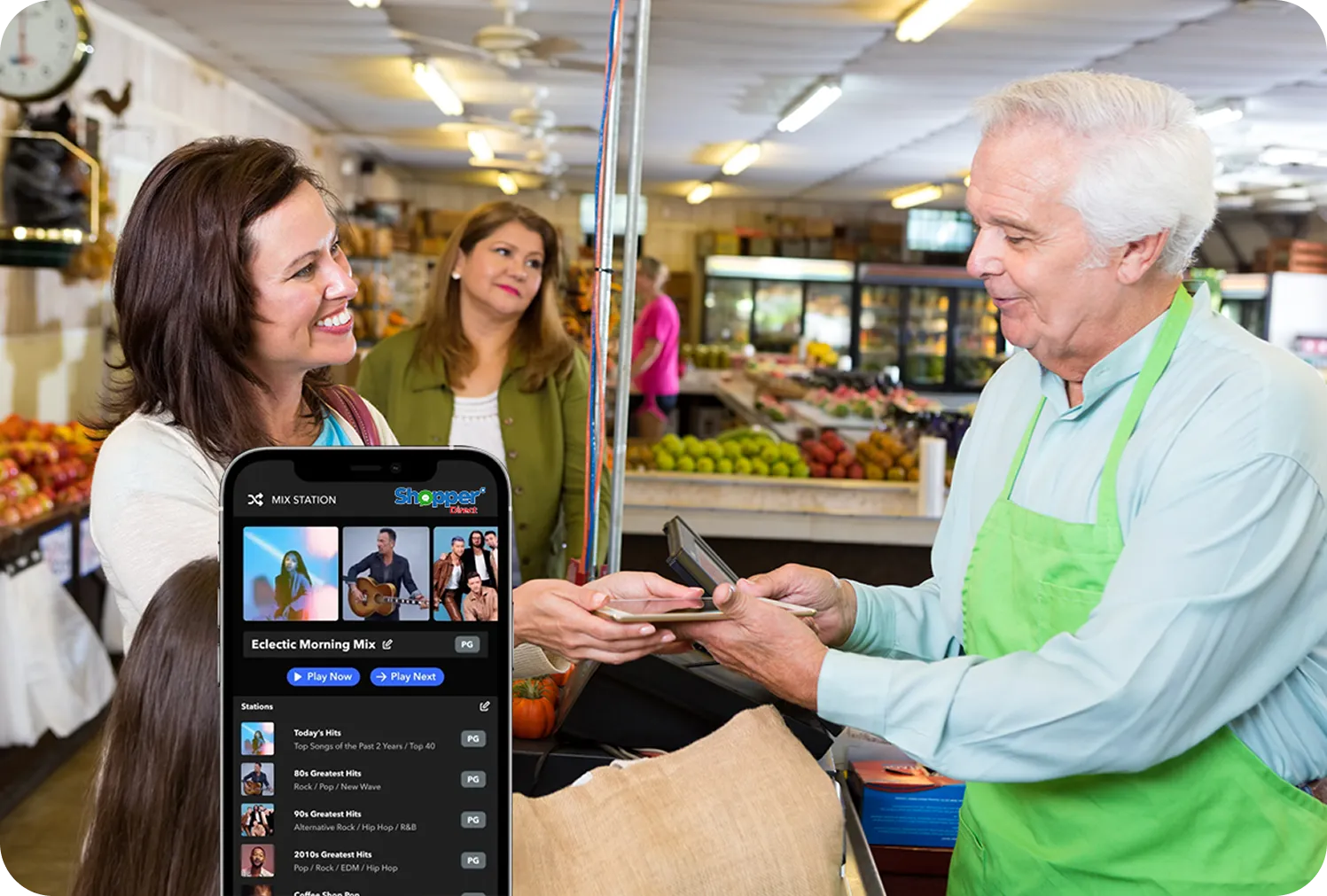 A smartphone displaying the Shopper Direct "Mix Station" app with curated playlists like "Eclectic Morning Mix," overlaid on a scene of a friendly grocer interacting with a shopper at checkout.