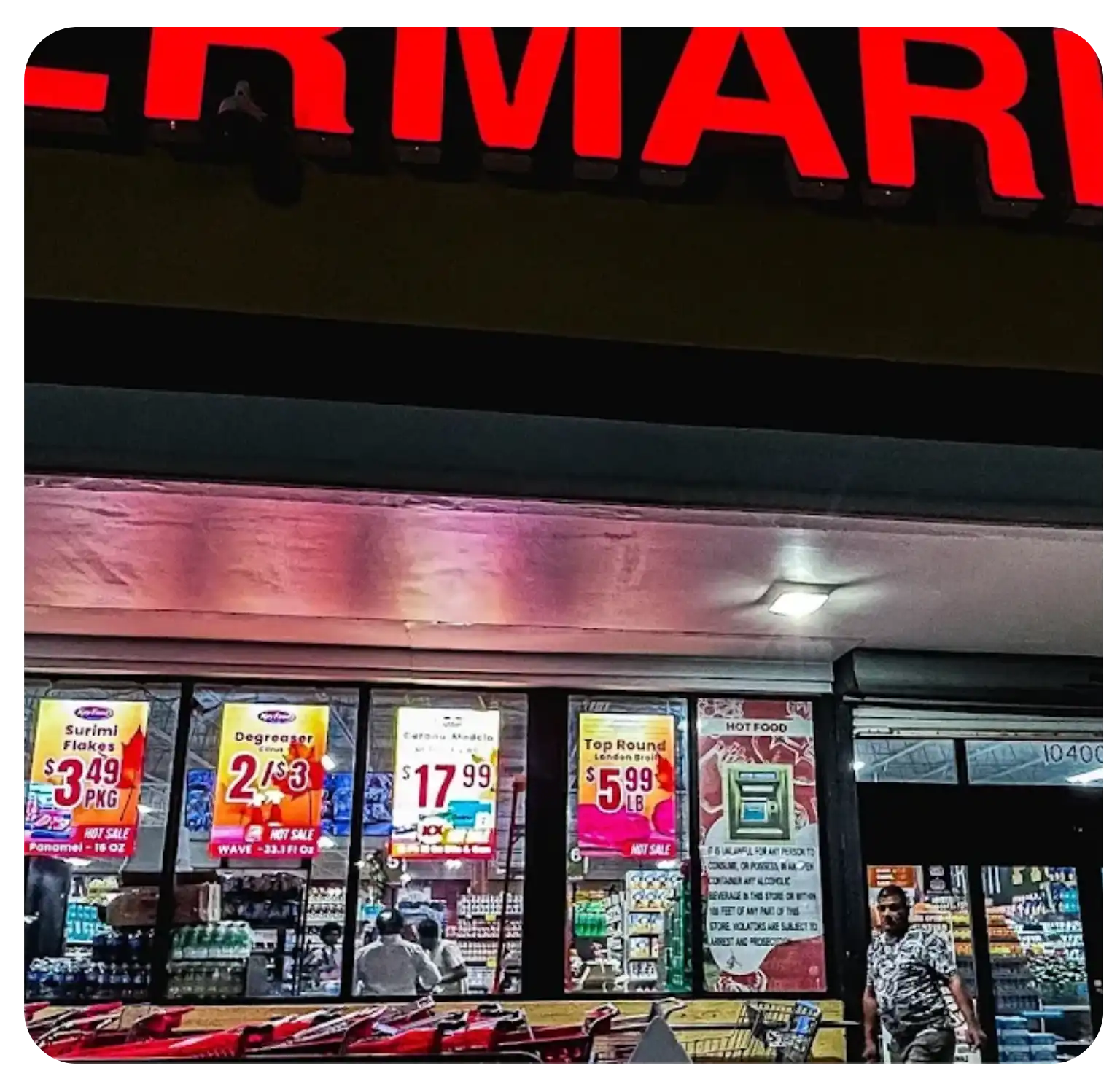 Ultra-bright LED window displays at a supermarket storefront showing digital price posters and hot sales for items like surimi flakes and top round beef.
